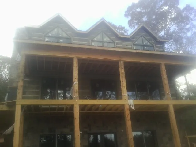 Dormers and porch framing on a large log home under construction — Roof Coating work by our crew in Moclips